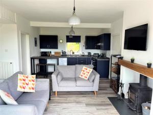 a living room with a couch and a kitchen at Mallaig in Rockcliffe
