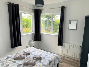 a bedroom with a bed and two windows at Mallaig in Rockcliffe