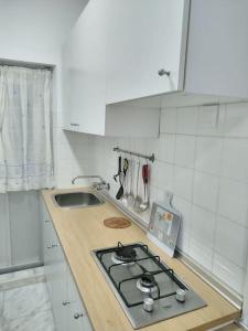 a white kitchen with a stove and a sink at Cozy Apartment in Chiclana City Center by Chiclana Dreams in Chiclana de la Frontera