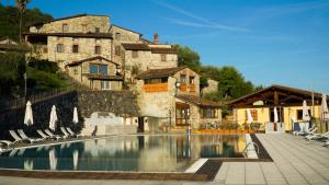 a hotel with a swimming pool in front of a building at Borgo Giusto Tuscany in Diecimo