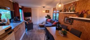 una cucina e un soggiorno con divano di Gezellige chalet met grote privétuin. a Dronrijp