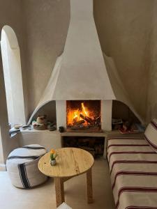 - un salon avec une cheminée et une table dans l'établissement Riad BB Marrakech, à Marrakech