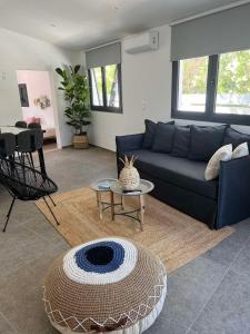 sala de estar con sofá azul y mesa en Mythos Luxury Villa-Skiathos en Troulos