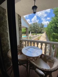 patio con mesa y sillas en el balcón en El Magnoliio en Santa Cruz de Pinares