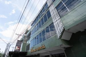 棉蘭的住宿－New Gentala Hotel Mitra RedDoorz，建筑的侧面有标志