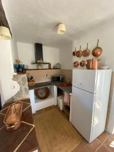 a kitchen with a white refrigerator and a counter at Cor de Azeitona in Aldeia do Mato +5 photos