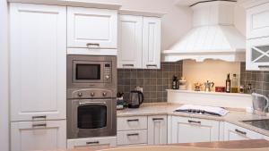 City Center - Alba di Perugia في بيروجيا: مطبخ بخزائن بيضاء وفرن موقد +14 صورة