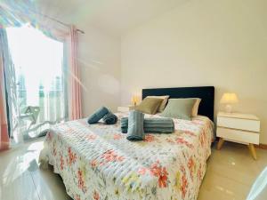 a bedroom with a bed with a floral bedspread at PêraDoce - Beach 150m - Terrace - Private Parking in Armação de Pêra