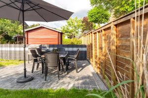 een patio met een tafel en stoelen en een parasol bij Arkadia Apartments-Schwissel-Bad Segeberg in Schwissel