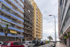 eine Straße mit Autos, die vor den Gebäuden geparkt sind in der Unterkunft Provence, 5º-18 in Cullera