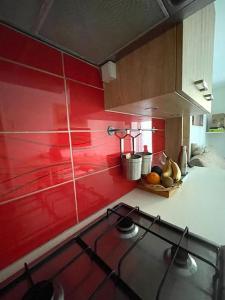 a kitchen with red walls and a stove top at Havre de paix Annécien in Meythet