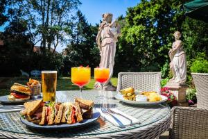 una mesa con platos de comida y vasos de zumo de naranja en Angmering Manor Hotel, en Angmering
