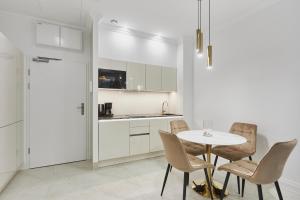 a kitchen and dining room with a table and chairs at Seaside Garden by Baltic Home in Świnoujście