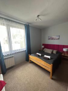 um quarto com uma cama com uma cabeceira vermelha em Willa Karolina em Czorsztyn