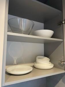 a cupboard with plates and bowls in it at Palanga Studios in Palanga