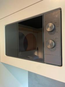 a microwave oven with two knobs on a wall at Palanga Studios in Palanga
