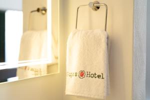 a towel hanging in a bathroom next to a mirror at Jupa's Hotel in Düsseldorf