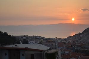 une ville au coucher du soleil sur l'océan dans l'établissement AYMESEV REZİDANS, à Çeşme