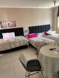 a hotel room with two beds and a table and chairs at DINASTIE PALACE in Chajarí