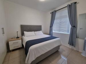 Un pat sau paturi într-o cameră la Beachfront Apartment on Muizenberg Surfers Corner