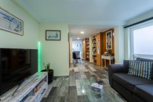 a living room with a couch and a flat screen tv at Mateus House - Porto da Cruz Center in Porto da Cruz