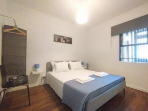 1 dormitorio con 1 cama con 2 toallas en Laranjal Guesthouse, en Vila do Conde