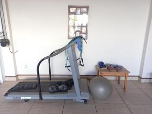 a treadmill in a room with a ball and a table at Hospedagem Aconchegante in Espirito Santo Do Pinhal