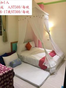 a bedroom with two beds with mosquito nets at Formost Hotel in Kenting