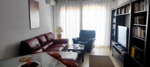 ein Wohnzimmer mit einem Sofa und einem Stuhl in der Unterkunft Apartamento con vistas panorámicas al mar, golf, puerto deportivo in Almerimar