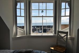 a bedroom with a window with a view of the ocean at Bass View- harbourfront home Pittenweem in Pittenweem