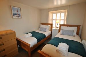 1 dormitorio con 2 camas y ventana en Aqua Vista- seafront cottage Cellardyke en Anstruther