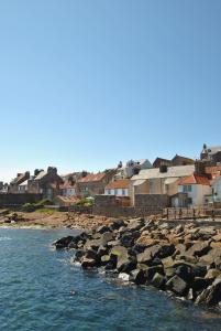 a group of houses on the shore of a body of water at Aqua Vista- seafront cottage Cellardyke in Anstruther