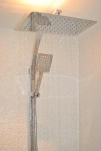 a shower with a shower head in a bathroom at Aqua Vista- seafront cottage Cellardyke in Anstruther