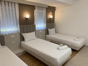 een kamer met 2 bedden en 2 ramen bij Royal L Hotel in Carev Dvor