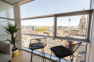 two chairs in a room with a view of a city at Skyline Views Free Parking Near Dale Street in Liverpool