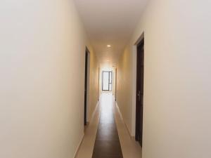 an empty corridor with white walls and wooden floors at Hotel Better Inn in Ernakulam