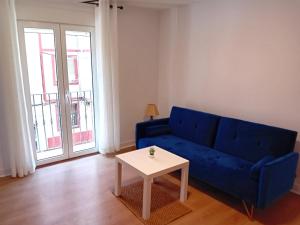 a living room with a blue couch and a table at Santa Olalla en el norte in Santander