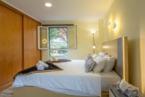 a bedroom with a large bed with a window at Mateus House - Porto da Cruz Center in Porto da Cruz