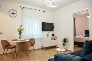 uma sala de estar com um sofá e uma mesa com cadeiras em Mediterano Zara em Zadar