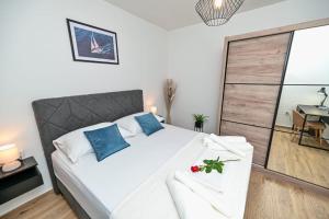 um quarto com uma grande cama branca com almofadas azuis em Mediterano Zara em Zadar