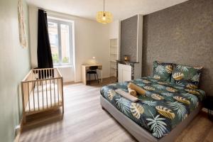 1 dormitorio con cama y cuna en LD-Location Hôtel en Montluçon