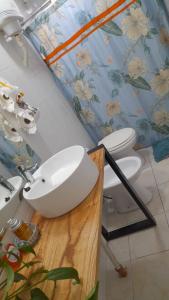 baño con lavabo blanco y 2 aseos en CASA EN JUANA KOSLAY San Luis con pileta, en San Luis