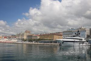 a large boat docked in the water near a city at Residence INN Rijeka in Rijeka