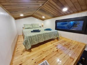 a bedroom with a bed and a flat screen tv at Antik Tiny House in İznik