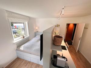 Habitación pequeña con cama y ventana en Eisvogel, en Oberstaufen