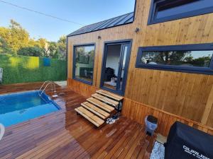 una terraza de madera con piscina y una casa en Antik Tiny House, en İznik