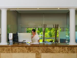 Una donna seduta a una scrivania in un ufficio di Hotel Spa Atlántico San Vicente do Mar a San Vicente do Mar