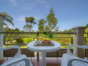 a table with a plate of food on a balcony at Hotel Spa Atlántico San Vicente do Mar in San Vicente do Mar