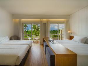 a hotel room with two beds and a desk at Hotel Spa Atlántico San Vicente do Mar in San Vicente do Mar +95 photos