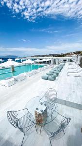 a patio with chairs and a swimming pool at Mykonos Bay Resort & Villas in Mikonos